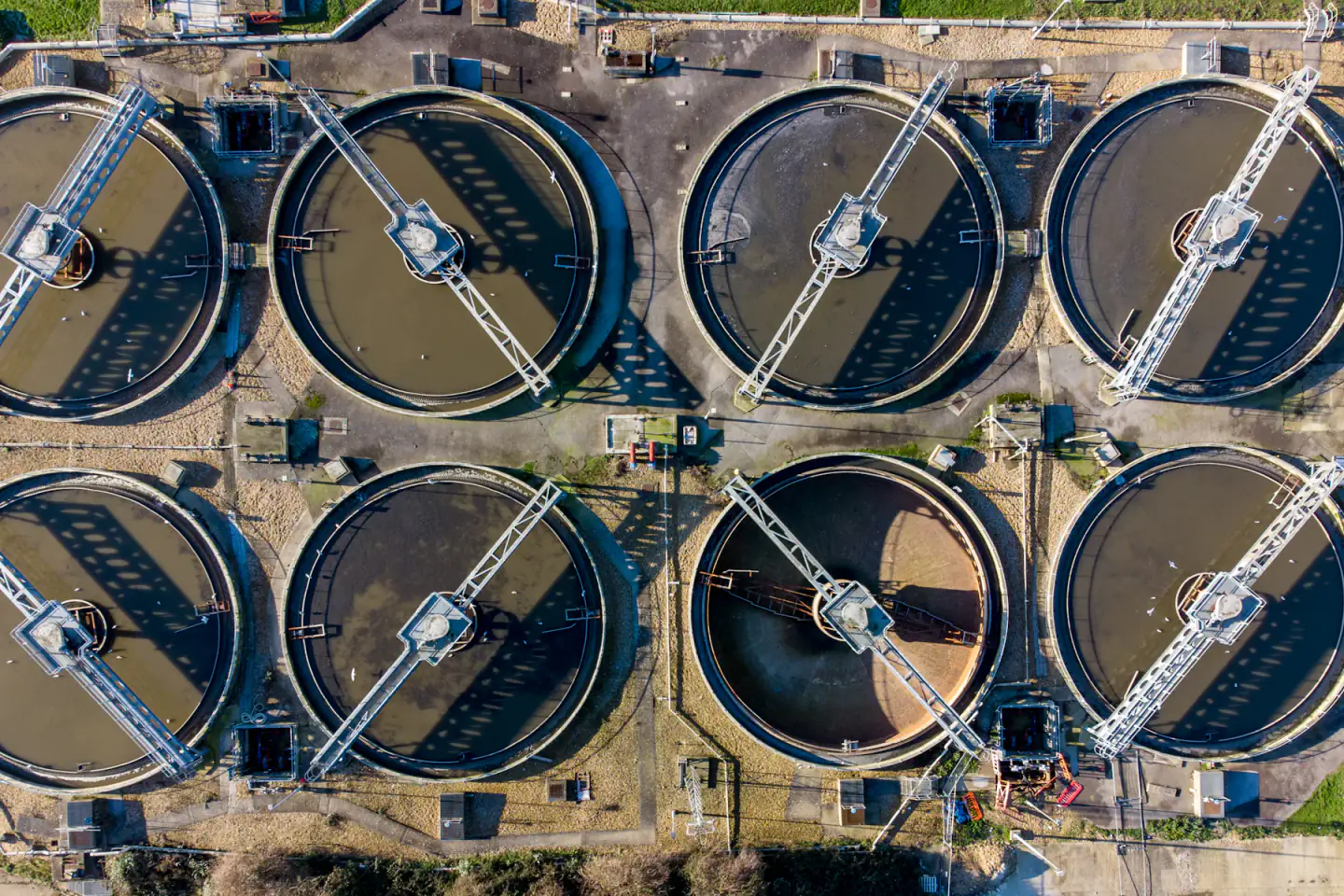 Vue aérienne de plusieurs bassins de traitement intégrés à un vaste réseau d’infrastructures.