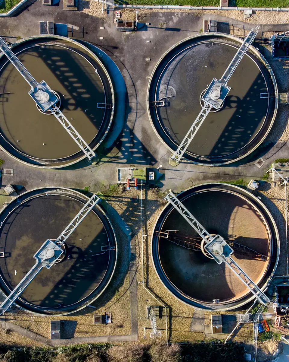 Vue aérienne d’une installation de traitement organisée en bassins circulaires.